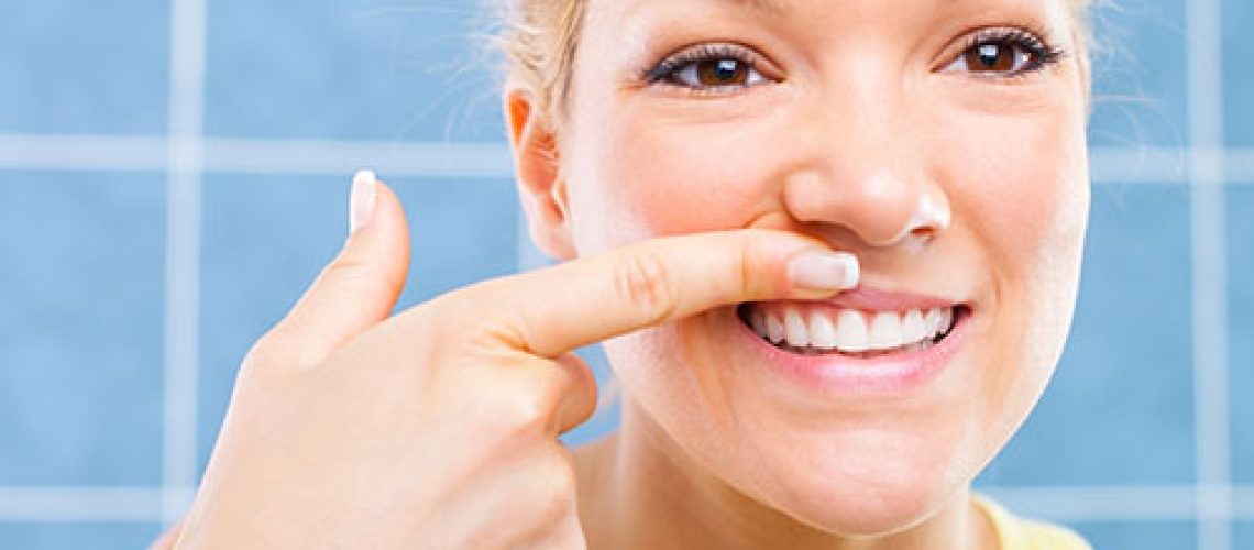 Female showing her healthy gums and smiling